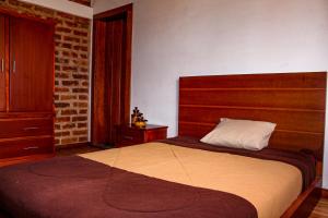 a bedroom with a large bed and a brick wall at Comunidad La Moya, Calpi in Riobamba