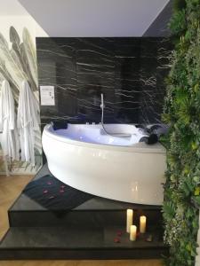 Ett badrum på Escapade Mâconnaise Spa-Sauna-Ciel de pluie tropicale-Champagne Nuit Romantique