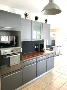 una cucina con mobili bianchi e un piano di lavoro di Maison piscine 4 ch Carcans Médoc Bassin Arcachon a Carcans