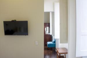 sala de estar con TV de pantalla plana en la pared en Hotel Casa de la Vega, en Bogotá