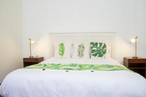 a bedroom with a white bed with two night stands at Hotel Casa de la Vega in Bogotá