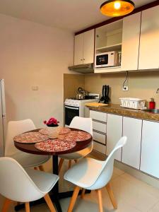 Una cocina con una mesa y sillas en una cocina. en Lindo dpto con vista al jardin, internet y cable, en Lima 13 fotos más