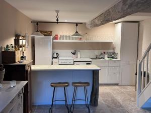 una cucina con due sgabelli su un'isola blu di Maison Marie a Lagarde