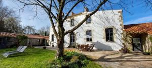 uma casa branca com uma árvore no quintal em Au Logis de la Mongie em Soullans