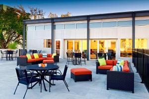 a patio with couches and tables and chairs at Aloft Tulsa Downtown in Tulsa