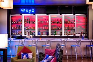 a bar in a restaurant with a lot of bottles at Aloft Tulsa Downtown in Tulsa