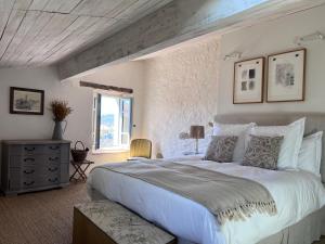una camera da letto con un grande letto bianco e una finestra di Maison Marie a Lagarde