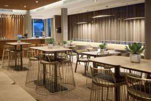 a restaurant with tables and chairs and a bar at SpringHill Suites by Marriott Medford Airport in Medford
