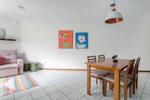 ein Wohnzimmer mit einem Tisch, Stühlen und einem Sofa in der Unterkunft Condomínio com Piscina no Itacorubi #ITAA08 in Florianópolis