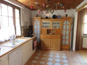 a large kitchen with wooden cabinets and a tile floor at Landhausstil trifft Moderne in Muhlheim am Main