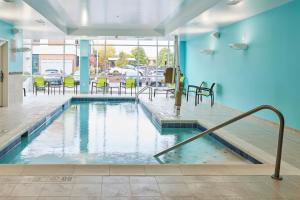 a swimming pool with chairs and tables in a building at SpringHill Suites by Marriott Medford Airport in Medford