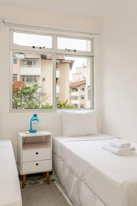 1 Schlafzimmer mit 2 Betten und einem Fenster in der Unterkunft Condomínio com Piscina no Itacorubi #ITAA08 in Florianópolis