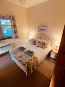 a bedroom with a large bed with two pillows at Talisker in Nairn
