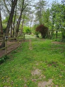 a dirt path in a field next to a fence at Roulotte d'Aquitaine in Saint-Sulpice-de-Faleyrens