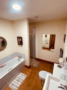 a bathroom with a tub and a toilet and a sink at Talisker in Nairn