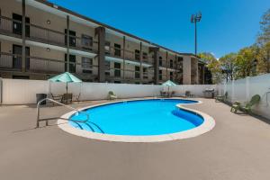 a swimming pool in front of a building at Quality Inn & Suites Airport in Charlotte