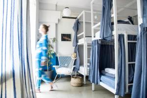 a woman walking through a bedroom with bunk beds at Let me take my bunk bed in Athens