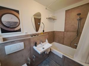 a bathroom with a sink and a bath tub at Ferienhaus 13b in Bad Orb