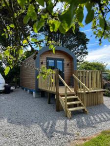 a small building with a wooden ramp and a porch at A Unique & Tranquil Smallholding Retreat in Redruth