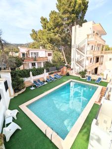 an image of a swimming pool with chairs and a house at Don Carlos in Paguera