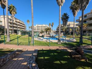 un parque con palmeras y una piscina en VilaBplaza by JohnVillas en Alvor
