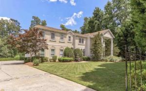 a large white house with a yard at 7000 sf: 5 king / 1 queen / 7 single beds, heated pool/spa, designer furnishings in Flowery Branch
