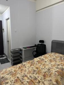 Apartemen Serpong Greenview Premium في Ciater-hilir: غرفة نوم فيها سرير ومكتب