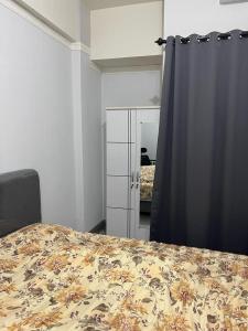 een slaapkamer met een bed, een dressoir en een spiegel bij Apartemen Serpong Greenview Premium in Ciater-hilir