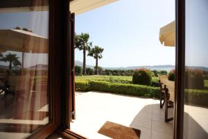 a view from a glass door of a patio with palm trees at Seaside Gialova in Pylos