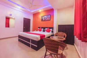 a bedroom with a bed and a table and chairs at The Orchid Guest House Near Phugewadi Metro Station in Khadki