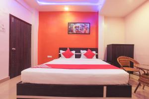 a bedroom with a large bed with an orange wall at The Orchid Guest House Near Phugewadi Metro Station in Khadki