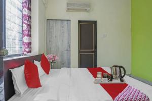 a bedroom with a large bed with red and white pillows at R K Exclusive in Hinjewadi