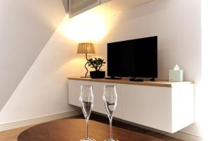 two wine glasses sitting on a table in front of a tv at Casa Vitoria in Aguilar de Campóo