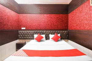 een slaapkamer met een bed met rode muren bij OYO Flagship Hotel Preet Palace in Rānchī