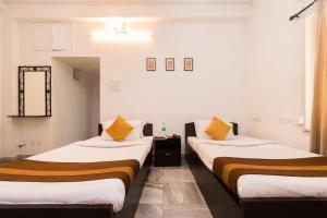 two beds sitting next to each other in a room at Rathi Kunj Near City Centre Salt Lake in Salt Lake City