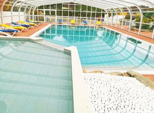 duży basen z krzesłami w budynku w obiekcie Camping Les Moutiers-en-Retz w mieście Prigny