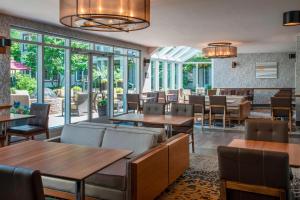 un restaurante con mesas, sillas y ventanas en Residence Inn by Marriott Mont Tremblant Manoir Labelle en Mont-Tremblant