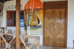 un edificio con dos puertas y una pintura en la pared en Villa Sunshine House ZANZIBAR, en Jambiani