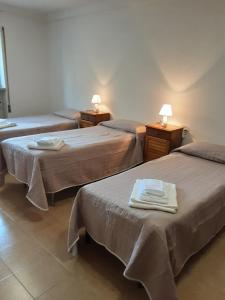 a hotel room with three beds with towels on them at La Cascina di Fox in Terni