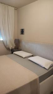 2 letti posti uno accanto all'altro in una camera da letto di Casa Rosanna a Peschiera del Garda