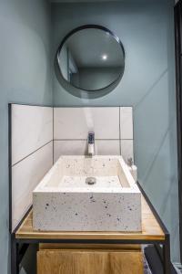 a bathroom with a sink with a round mirror at Park Lane Studio, Shouldham in Shouldham