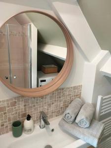 a bathroom with a mirror and a sink with towels at La Closerie de Thimécourt in Luzarches