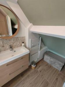 een badkamer met een wastafel en een spiegel bij La Closerie de Thimécourt in Luzarches
