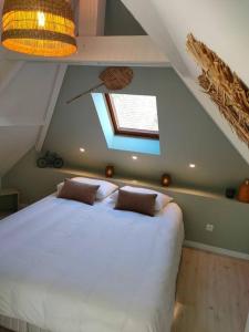 a bedroom with a large white bed in a attic at La Closerie de Thimécourt in Luzarches