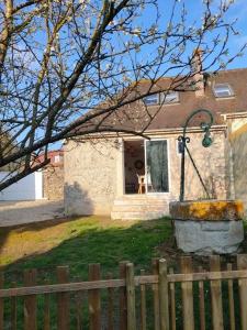 a small house with a fence in front of it at La Closerie de Thimécourt in Luzarches