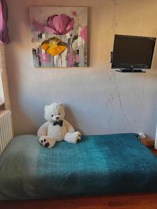 a teddy bear sitting on top of a bed at Le Passage du Faubourg, agréable T3 en duplex de 120m2 in Saint-Léonard-de-Noblat
