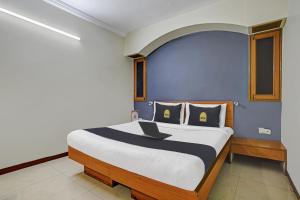 - une chambre avec un lit et un ordinateur portable dans l'établissement Townhouse OAK Utsav Residency, à Indore