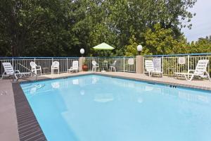 uma grande piscina azul com cadeiras e guarda-sóis em Fairfield Inn & Suites Charlotte Arrowood em Charlotte