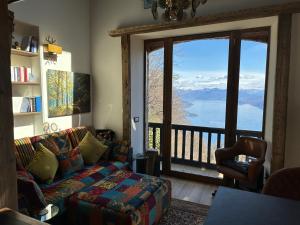 sala de estar con sofá y ventana grande en Private Luxury Spa & Silence Retreat with Spectacular View over the Lake Maggiore, en Stresa