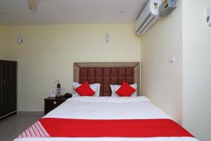 a bedroom with a large bed with red pillows at OYO Ma Classic Inn in Bhubaneshwar